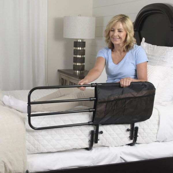 A woman is standing in bed with her arms on the rail.